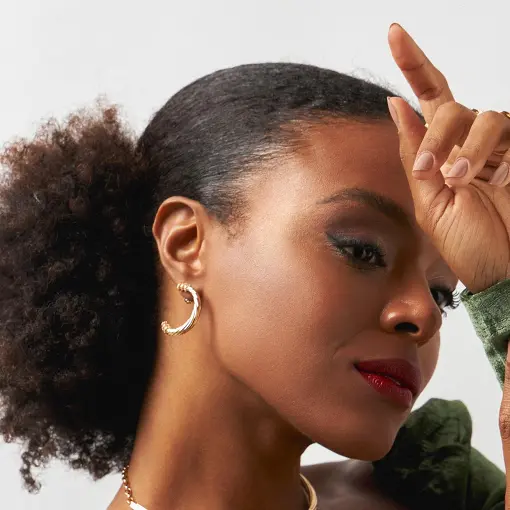 BRINCO CURVO TEXTURIZADO E ZIRCÔNIAS BANHADO A OURO